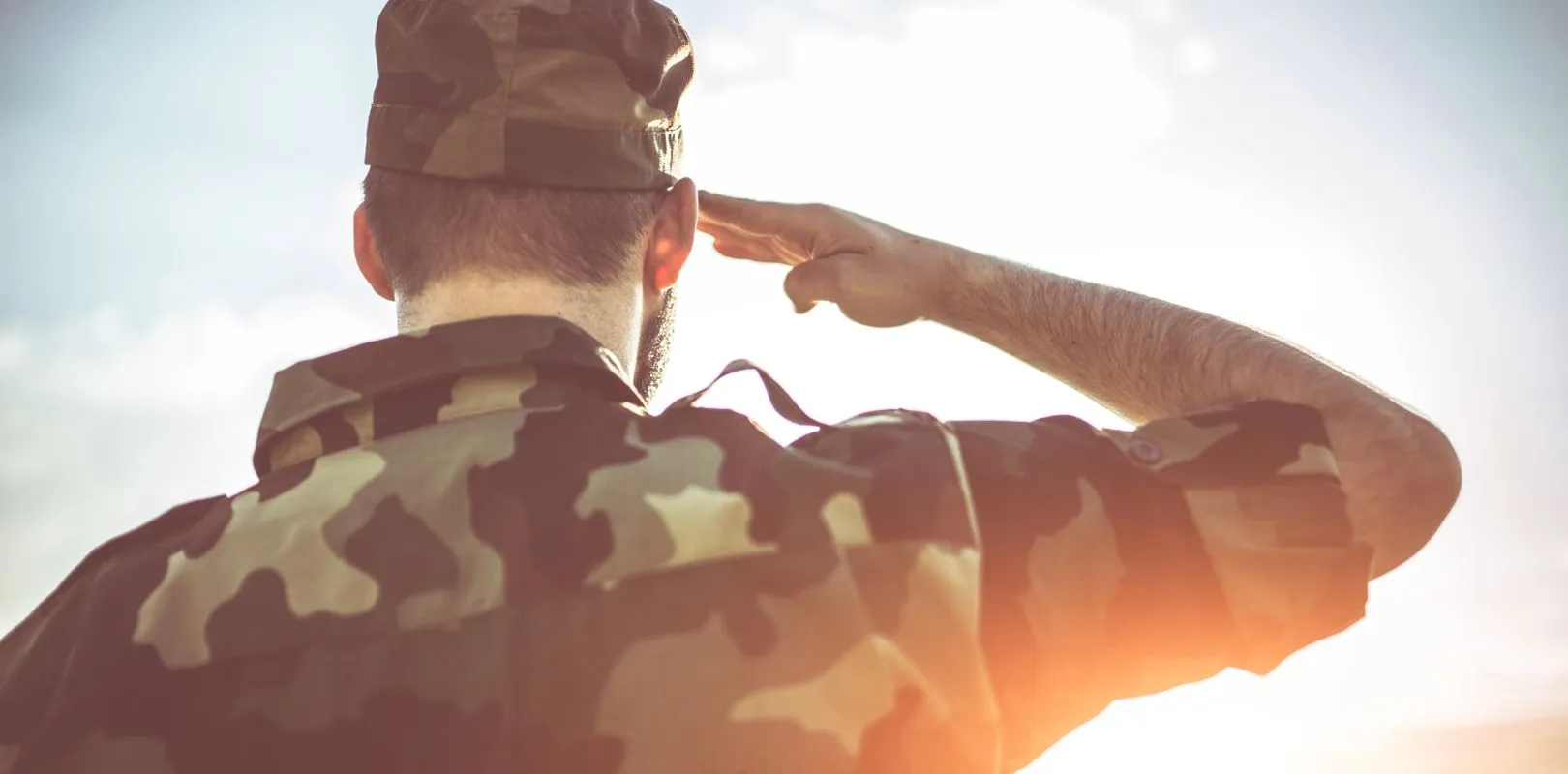 A soldier saluting at sunrise