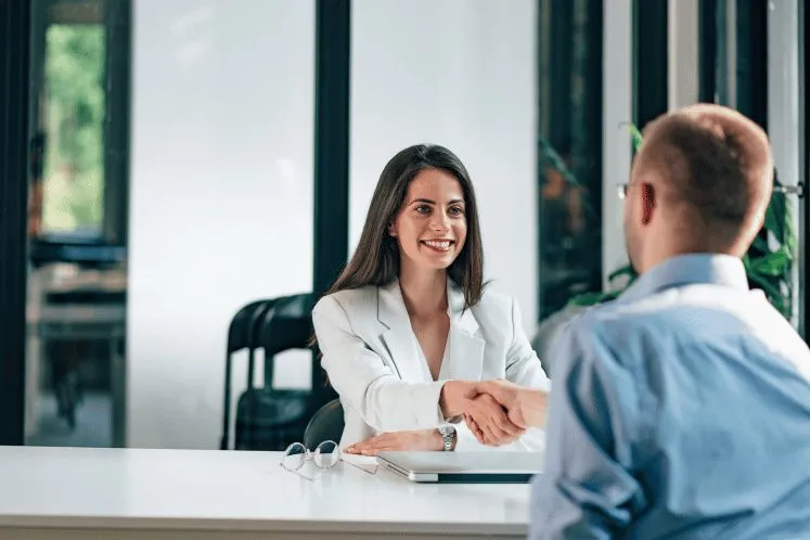A recruiter interviewing a candidate across a desk
